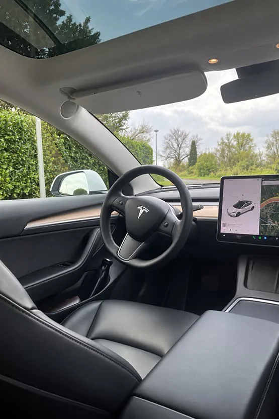 Volant, tableau de bord et écran central à l’intérieur d’une Tesla.
